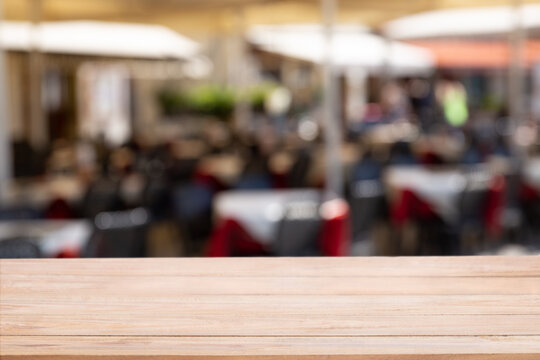 Empty table with Blurred abstract background of outdoor cafe in Milan, Italy.