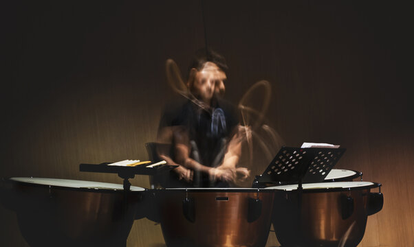 musician playing the drums or timpani with a long exposure capturing movement
