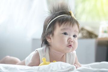 Closeup asian baby girl lie on carpet  in cute motion