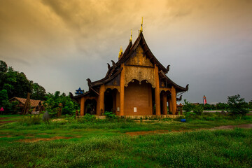 The background of the Wat Pa Kham Charoen is a beautiful old church with a Buddhist statue and a tree-lined temple, with tourists and travelers always making merit in Udon Thani, Thailand.