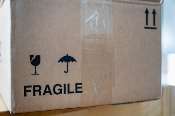 parcel box with fragile warning symbol - selective focus at the cardboard box for shipping	
