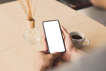 cell phone mockup image blank white screen.man hand holding texting using mobile on desk at coffee shop.background empty space for advertise.work people contact marketing business,technology