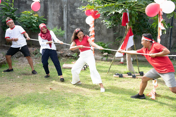 group of young people took part in a tug of war competition during Indonesia's independence day...