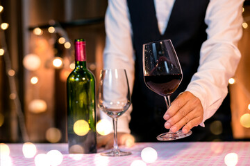 Waitress man pouring wine into glass