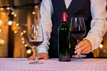 Waitress man pouring wine into glass