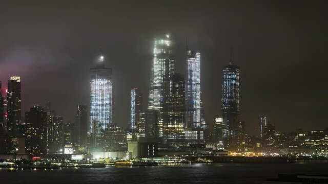 Buildings surrounded by clouds and fog across Hudson River at night, Manhattan