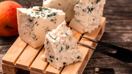 Dorblu cheese, Danish blue cheese on wooden background. Food recipe background. Close up
