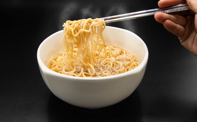 Boiled instant noodle in a bowl with chopstick