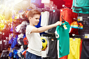 Boy with ball in football clothing store