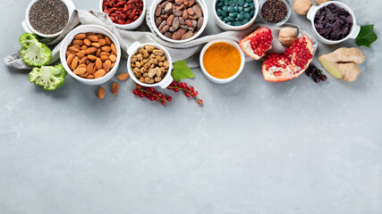 Various superfoods on grey background.