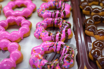 Beautiful colored junk food donuts lined up.