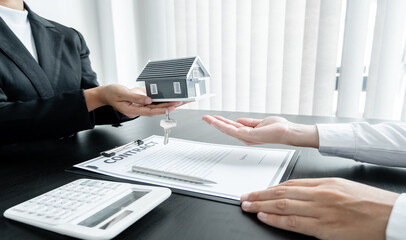 Real estate agent broker hand over the house key and home to the new owner after completing the signing according to agreement renting a house and buy house insurance Home insurance concept