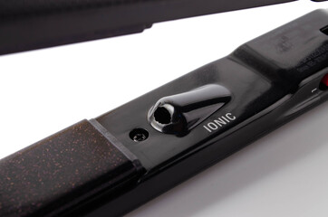 Iron, hair straightener. Align hair, curls, hairstyle. Leveler on a white background in close-up,...