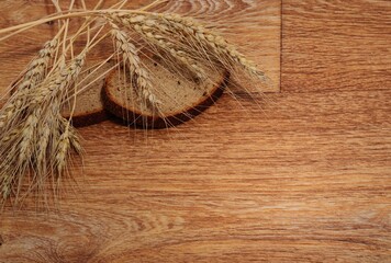 rye bread with ears of wheat on a wooden background