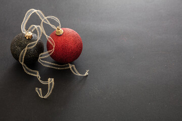 Christmas red and black balls against black background, copy space