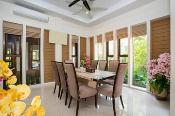 Interior design of house, home and villa feature dining table, dining chair and yellow artificial flower in big pot.