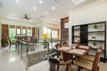 Interior design of house, home and villa feature dining table, dining chair and yellow artificial flower in big pot.