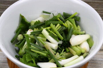 Pile of cutting spring onion in the bowl. Famous traditional herbal vegetable ingredients in Asia restaurant. Preparation food concept. 