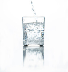 water is poured into a glass on a white background