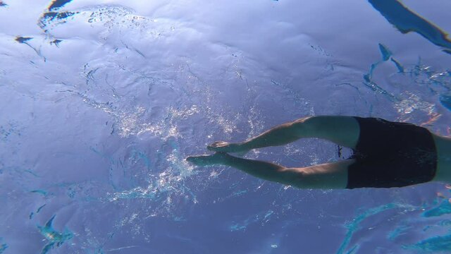 young man and young woman swimming breaststroke in the pool