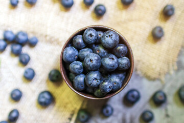 Blueberry antioxidant superfood in a bowl on sackcloth background. Healthy eating and nutrition concept.