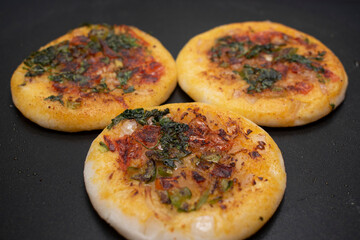 three mini round( circular) utappam on hot black non tick tawa or pan