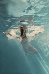Portrait of a girl in a blue dress under water  