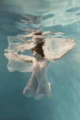 Portrait of a girl in a blue dress under water  