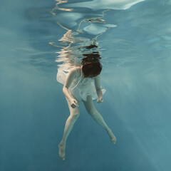 Portrait of a girl in a blue dress under water  