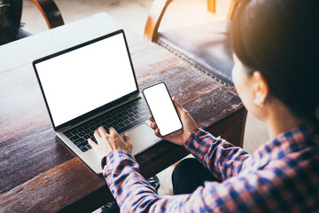 computer,cell phone mockup image.hand woman work using laptop texting mobile.blank screen with white background for advertising,contact business search information on desk in cafe.marketing,design