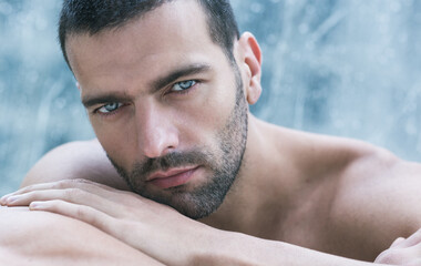 Sexy closeup portrait of handsome topless male model with beautiful eyes staring deep at the...