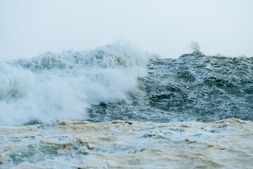 high seas and waves during Spring tide storm crashing down onto each other closeup