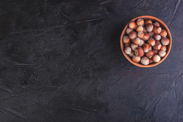 Hazelnuts in a clay bowl, with a place under the text