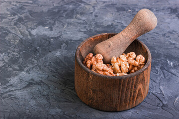 Almonds on a mortar with a pestle on a dark background