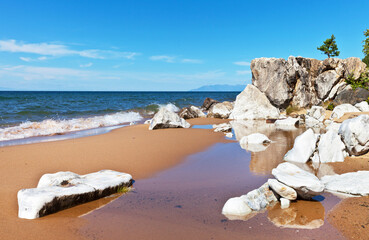 Fototapeta na wymiar Baikal Lake at sunny day. Beautiful landscape with sandy beach near white stones. Natural background, summer travel