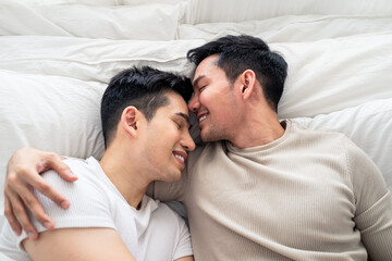 Obraz na płótnie Canvas LGBT, smile Asian gay lover homosexual couple lying on bed together.