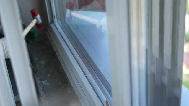 Worker put window sash into new installed frame. Close up of hand