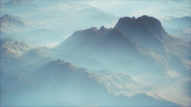 Distant mountain range and thin layer of fog on the valleys