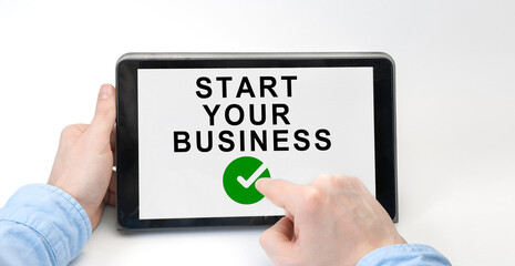Male hands holding tablet pc with START YOUR BUSINESS on white background