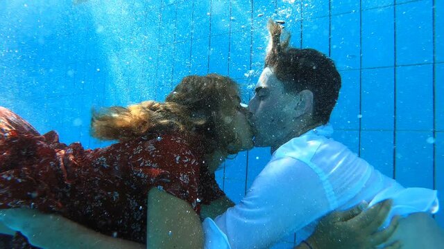 underwater shot of young couple kissing underwater in the pool