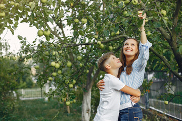 Fashionable mother with son. Family in a spring park. Woman in a blue shirt