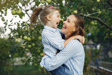 Fashionable mother with daughter. Family in a spring park. Woman in a blue shirt