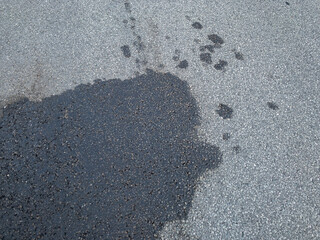 Background of black spot of motor oil on an asphalted street. Automobile and automotive concept.