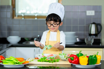 Happy Asian boy having breakfast with preparing food in the kitchen.