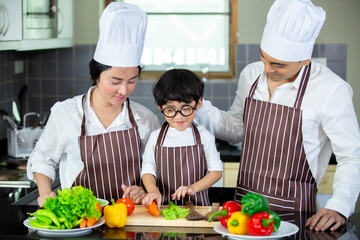 Happy Asian family having breakfast with preparing food in the kitchen.