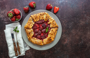 Galette with strawberry. Vegetarian berry tart with fresh sliced strawberries and mint. Delicious summer food dessert.