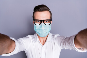 Self-portrait of his he attractive healthy guy wearing safety gauze mask stop contamination stay home influenza infection flu flue grippe pandemia preventive measures isolated gray color background