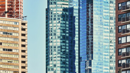 Fototapeta na wymiar Modern and old high rise building in New York City, architecture background, color toning applied, USA.