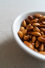 Plate with almonds on a light surface