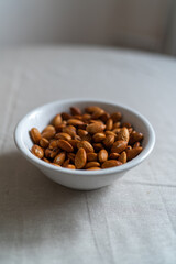 Plate with almonds on a light surface